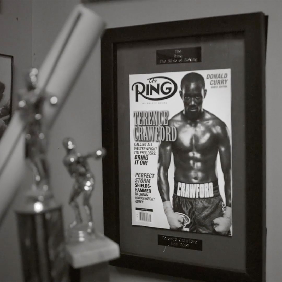 A framed magazine cover feating the famous boxed Terence Crawford sitting behind boxing trophies.
